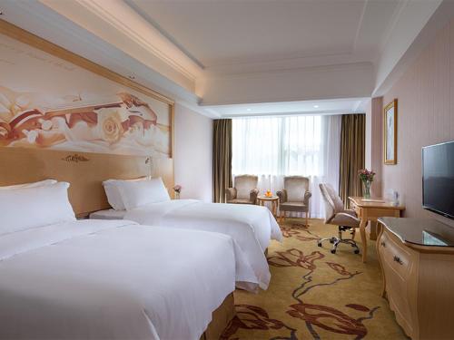 una camera d'albergo con due letti e una televisione di Vienna Hotel Shenzhen North Science And Technology Park a Shenzhen
