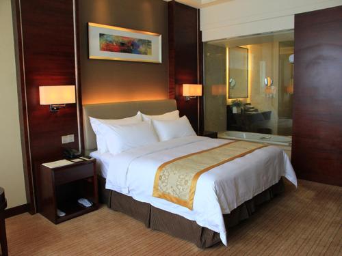 a bedroom with a large bed in a hotel room at Vienna Hotel Shenzhen Exibition Center in Shenzhen