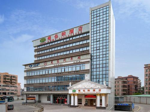 a large building with a sign on top of it at Vienna Hotel Longgang Longdong in Longgang