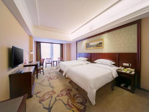 Un pat sau paturi într-o cameră la Vienna Classic Hotel Shizhongshan Avenue