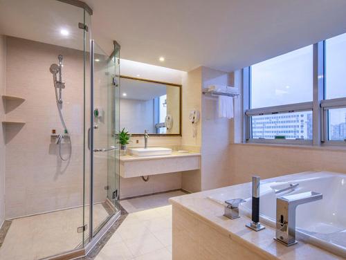 a bathroom with a shower and a sink and a tub at Vienna International Hotel Beijing GuangAnMen in Beijing