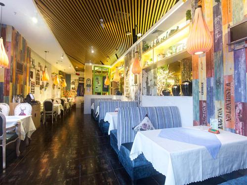 a restaurant with tables and chairs in a room at Vienna International Hotel Haikou West Bus Station in Haikou
