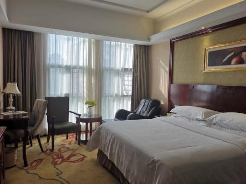 a hotel room with a bed and a desk and a room at Vienna Hotel Chaozhou Plaza in Chaozhou