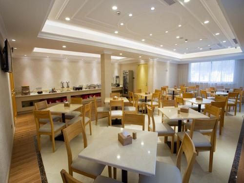 restauracja ze stołami i krzesłami oraz kuchnia w obiekcie Vienna 3 Best Hotel Taizhou Xianju w mieście Xianju