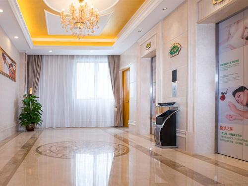 a large room with a chandelier and a large room with a hallway at Vienna Hotel Foshan Lecong Furniture Mall in Shunde