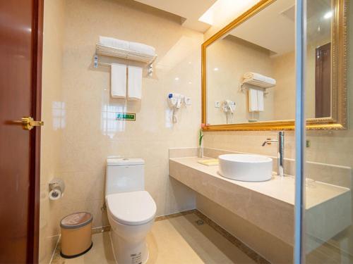 uma casa de banho com um WC, um lavatório e um espelho. em Vienna Hotel Zhejiang Huzhou Changxing Mingzhu Road em Changxing