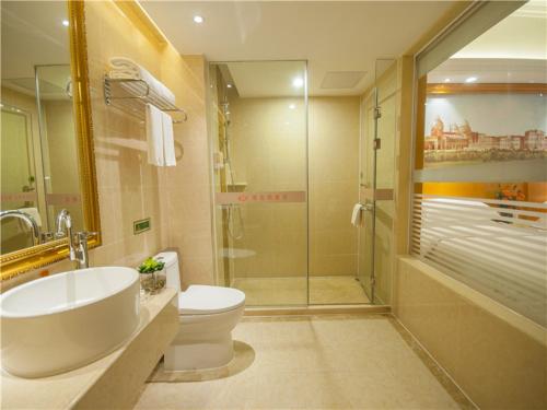 W łazience znajduje się umywalka, toaleta i prysznic. w obiekcie Vienna Hotel Yulin Jincheng Zhenlin w mieście Yulin