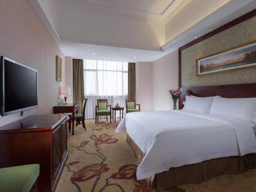 Vienna Hotel Dongguan Humen Huaibei Road tesisinde bir odada yatak veya yataklar