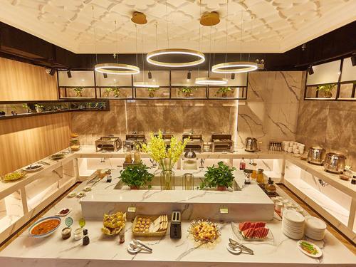 a large kitchen with a table with food on it at Vienna Hotel Nanyang People Road in Nanyang