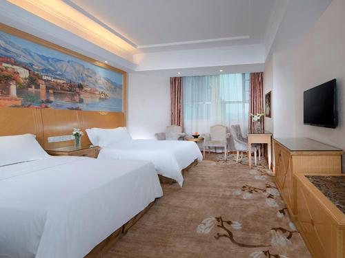 Habitación de hotel con 2 camas y TV de pantalla plana. en Vienna Hotel Dongguan Tangxia Lincun Square, en Dongguan