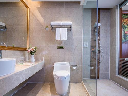 a bathroom with a toilet and a sink and a shower at Vienna Hotel (Shaoguan Qujiang Shunjing) in Shaoguan