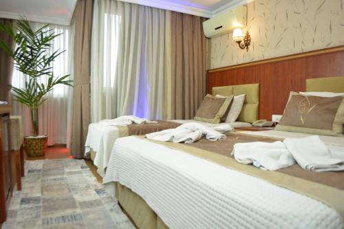 two beds in a hotel room with white towels on them at Hermanos Hotel in Istanbul