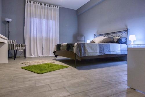 ein Schlafzimmer mit einem Bett und einem grünen Teppich in der Unterkunft Casa Di Amici in Caltanissetta