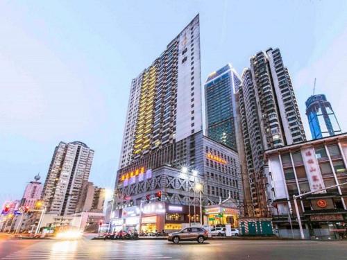 a city with tall buildings and a car on a street at Vienna Hotel CHangsha Bayi Bridge Hefu in Changsha