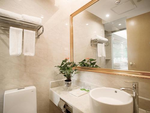 杭州市にあるVienna International Hotel Hangzhou Xintiandi Yingtaiのバスルーム(洗面台、鏡、トイレ付)