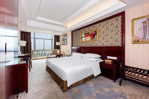 Vienna Hotel Xinyu Kaiguang tesisinde bir odada yatak veya yataklar