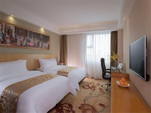 Habitación de hotel con 2 camas y TV de pantalla plana. en Vienna Hotel Dongguan ChangAn Wanda Plaza, en Dongguan