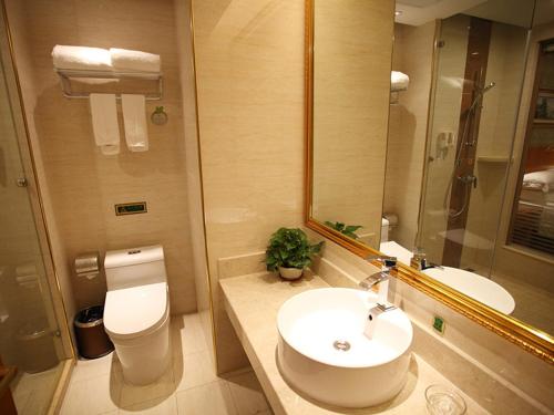 a bathroom with a sink and a toilet and a mirror at Vienna Hotel Jiangsu Kunshan Exhibition Center in Kunshan