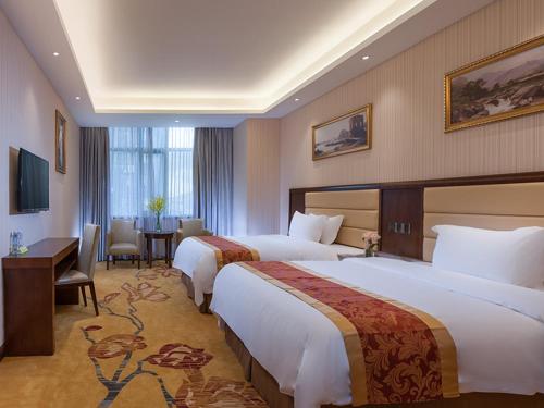 מיטה או מיטות בחדר ב-Vienna Hotel Shenzhen Gongming Bus Station