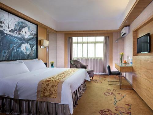 a hotel room with a large bed and a television at Vienna Hotel Guangzhou Airport 2 in Guangzhou