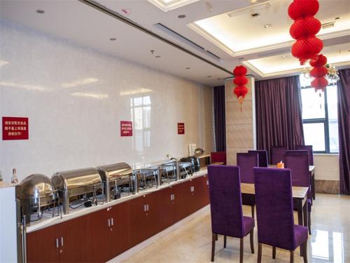 a restaurant with purple chairs and a table and red balloons at Vienna Hotel Jiangyin Qishan Road in Jiangyin