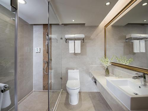 Un baño con inodoro, lavabo y ducha. en Vienna International Hotel Shenzhen Jingtian, en Shenzhen