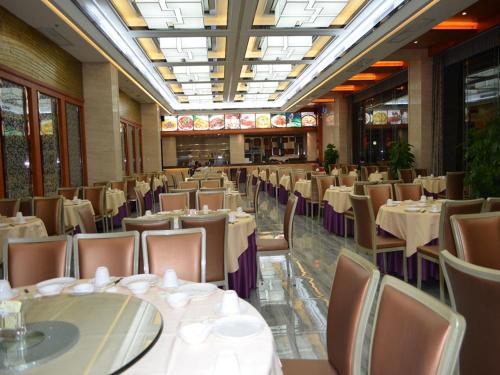 a dining room with tables and chairs in a restaurant at Vienna Hotel Dongguan Tangxia Guanlan Lake Golf Club in Dongguan