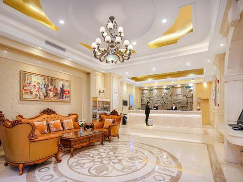 Habitación grande con lámpara de araña y muebles en un edificio en Vienna Hotel Jiangsu Shuyang Middle Renmin Road, en Shuyang
