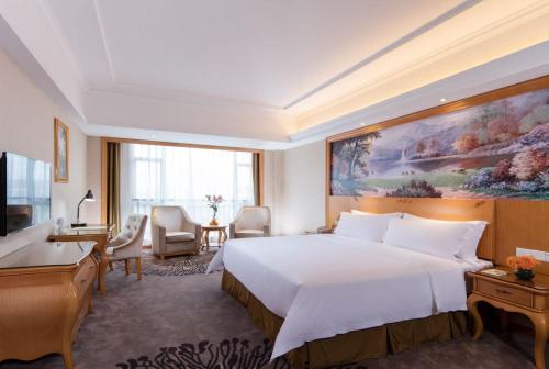 a hotel room with a large bed and a desk at Vienna Hotel Foshan Airport in Foshan