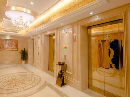 un couloir avec une grande porte en verre dans un bâtiment dans l'établissement Vienna International Hotel Shanghai Pudong New District Dishui Lake Univeristy City, à Nianbalian