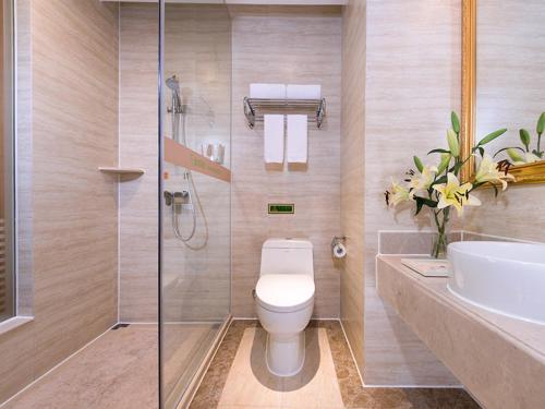 a bathroom with a toilet and a sink and a shower at Vienna Hotel Guangdong Maoming Railway Station in Maoming