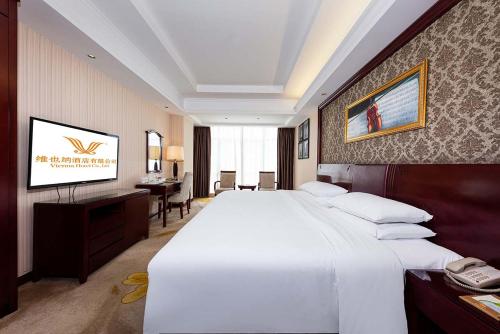 Una cama o camas en una habitación de Vienna Hotel Xinyu Kaiguang