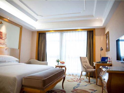 pokój hotelowy z łóżkiem i dużym oknem w obiekcie Vienna International Hotel Xuancheng Garden w mieście Xuanzhou