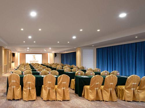a large room with chairs and tables and blue curtains at Vienna International Hotel (Jiaxing Nanhu Hotel) in Jiaxing