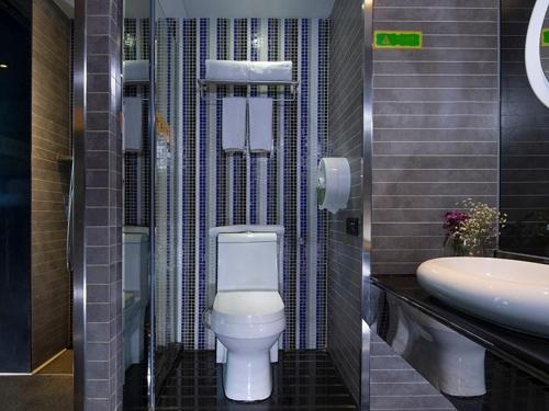 La salle de bains est pourvue de toilettes blanches et d'un lavabo. dans l'établissement Vienna Hotel Dongguan Houjie Avenue, à Dongguan