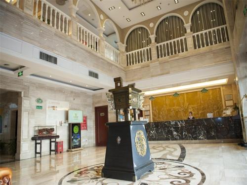 a large building with a lobby with a clock in the middle at Vienna Hotel Jiangyin Qishan Road in Jiangyin