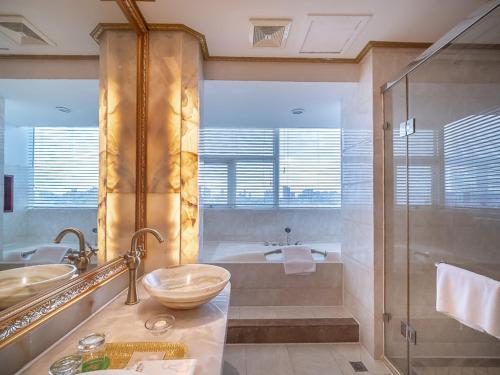 a bathroom with a shower and a sink and a tub at Vienna Hotel Foshan Chancheng Zumiao Branch in Foshan