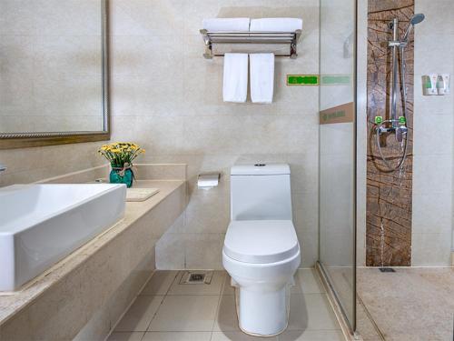 La salle de bains est pourvue de toilettes, d'un lavabo et d'une douche. dans l'établissement Vienna Hotel Guangzhou Airport, à Canton