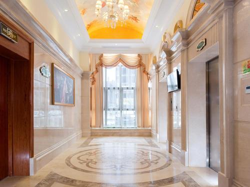 a hallway with a chandelier and a large window at Vienna International Hotel Shenzhen Caopu Jindaotian in Shenzhen