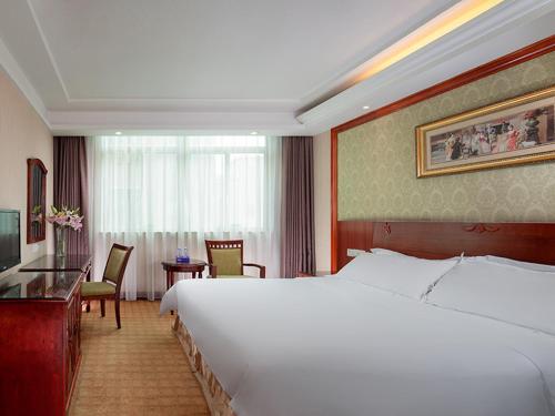 a hotel room with a large bed and a desk at Vienna Hotel Dongguan Songshan Lake in Dongguan