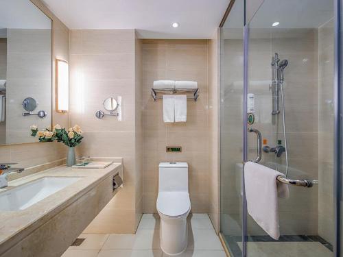 a bathroom with a shower and a toilet and a sink at Vienna International Hotel (Jiaxing Nanhu Hotel) in Jiaxing