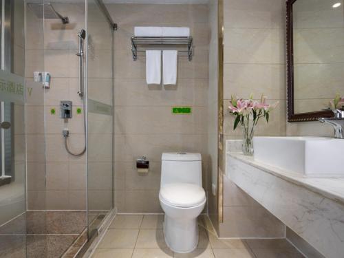 y baño con aseo, lavabo y ducha. en Vienna International Hotel Changzhou Hutang en Changzhou