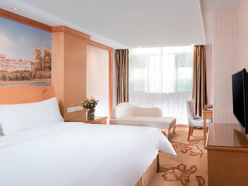 Ένα ή περισσότερα κρεβάτια σε δωμάτιο στο Vienna Hotel Qingyuan Yingde Guangming Road