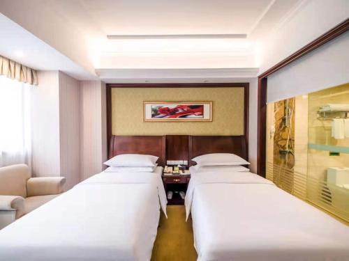 Ένα ή περισσότερα κρεβάτια σε δωμάτιο στο Vienna International Hotel Shanghai Pudong Xiupu Road