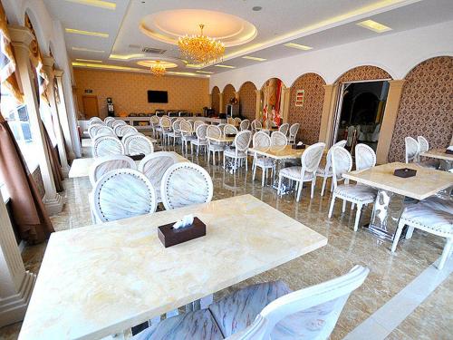 a dining room with white chairs and tables and tablesktop at Vienna Hotel Nantong Tongzhou Bus Station in Tongzhou