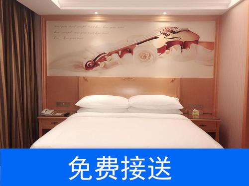 a hotel room with a bed with a sign above it at Vienna Hotel Guangzhou South Railway Station in Guangzhou