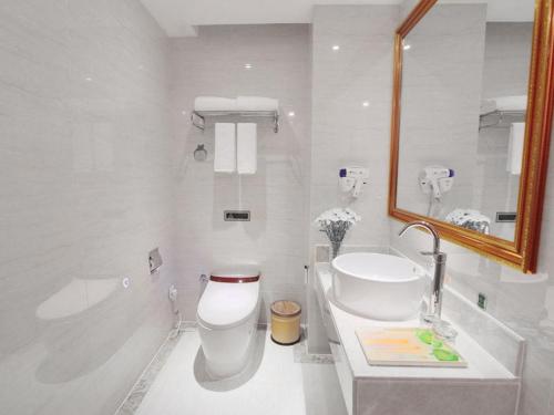 a white bathroom with a toilet and a sink at Vienna Hotel Hunan Yongzhou Lengshuitan District Government Square in Guzhuting