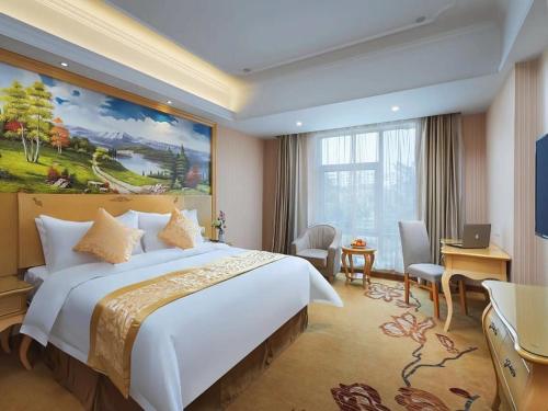 a hotel room with a large bed and a desk at Vienna Hotel Nanjing Olympic Sports Center in Nanjing