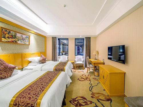 a hotel room with two beds and a television at Vienna Hotel Guilin Wanfu Square in Guilin
