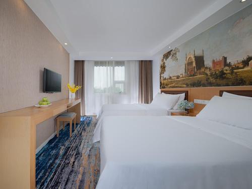 a hotel room with a large bed and a desk at Vienna 3 Best Hotel Beihai Sichuan Road in Beihai